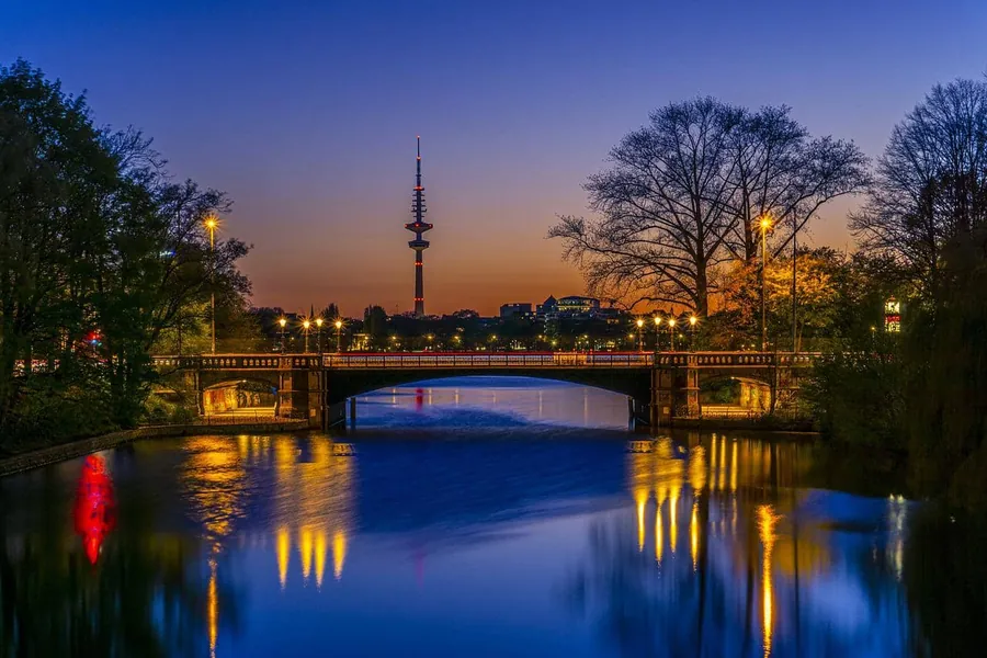 Brücke über die Alster mit Blick auf den Fernsehturm in der Dämmerung